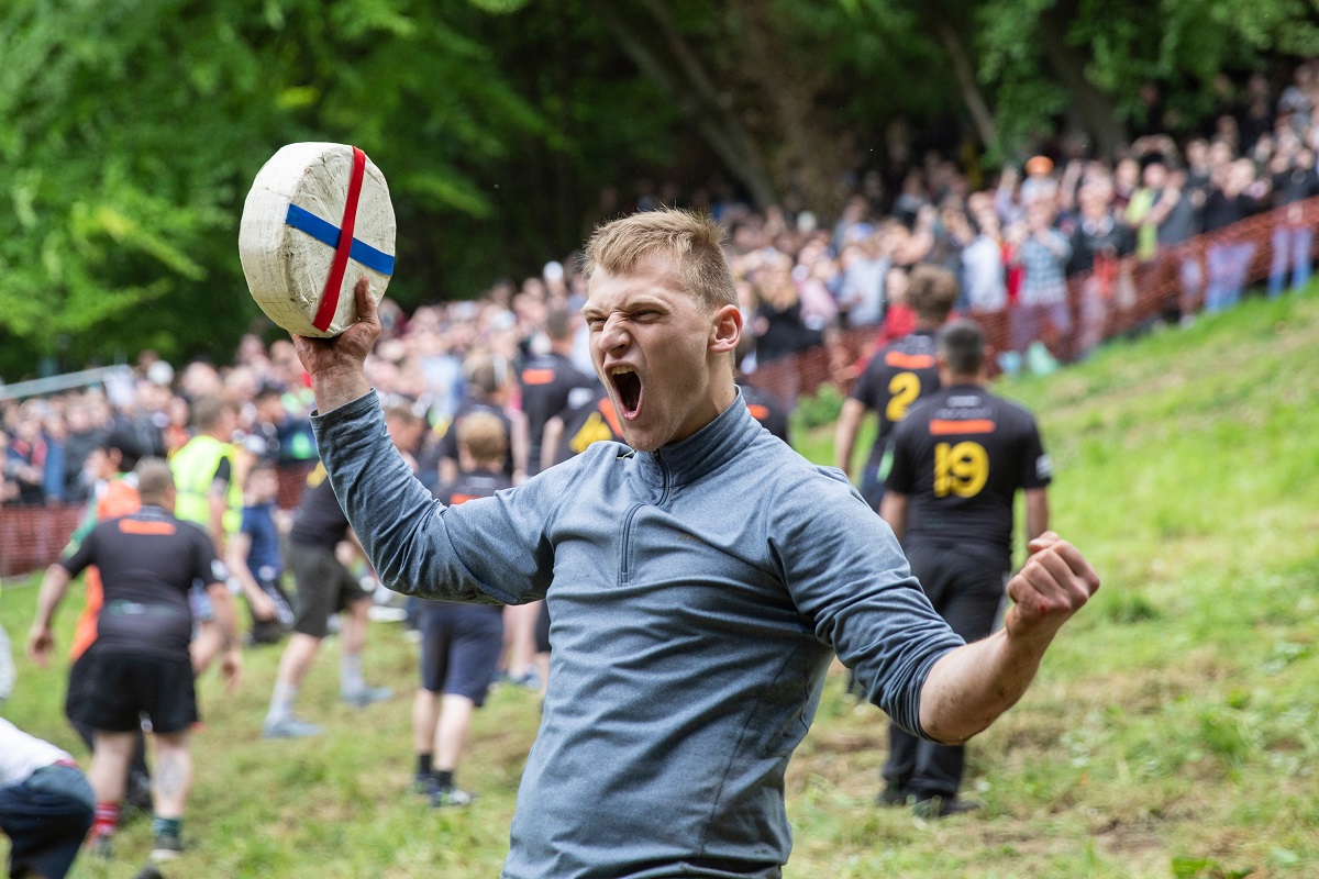 Canadian Mark Kit celebrates the annual Spring bank holiday cheese-rolling event near Gloucester. ComposedPix, Shutterstock