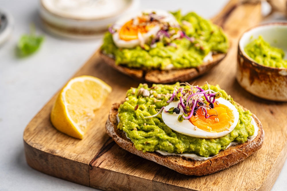 Study Reveals Best Hangover Cure 4 Toast with avocado, feta cheese, eggs, herbs and seeds with lemon slices