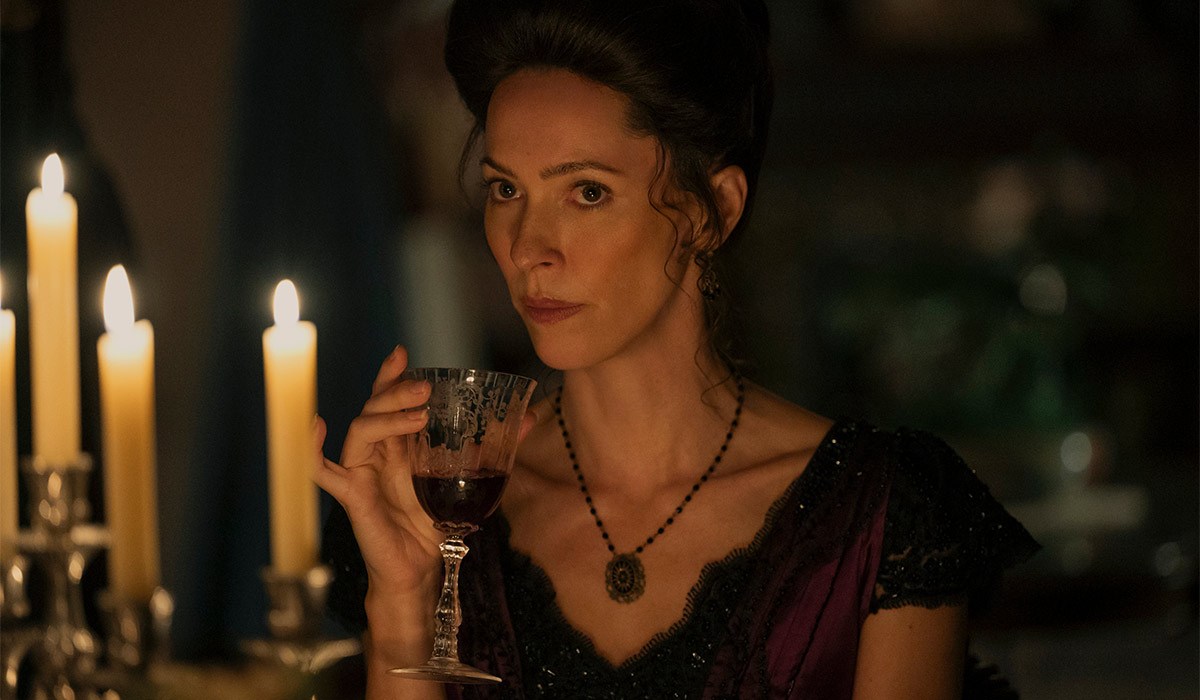 Dark and twisted new chapter of Monster series lands on Netflix 4 "Woman in period costume sits at a candlelit table, holding a glass of red wine, with a serious expression in a dimly lit, elegant room."